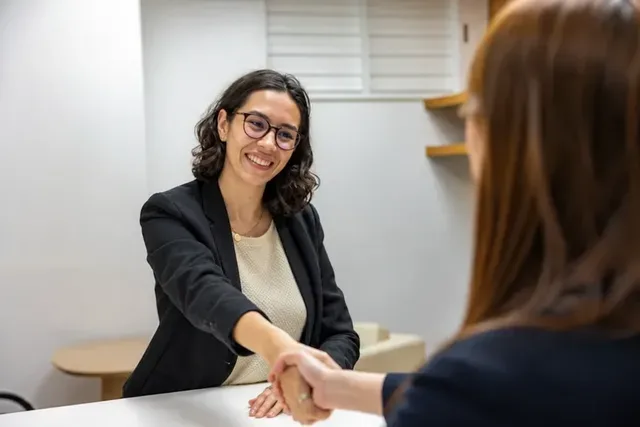 A recruiter welcoming a candidate with a handshake